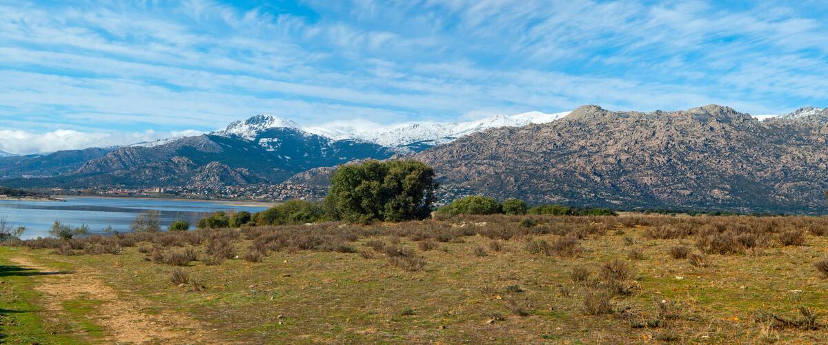 Paisagem montanhosa com um lago e uma cidade no vale.