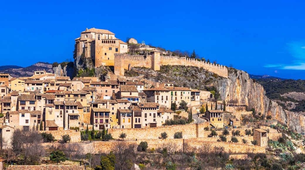 A historic town perched on a cliff with a prominent castle-like structure on top.
