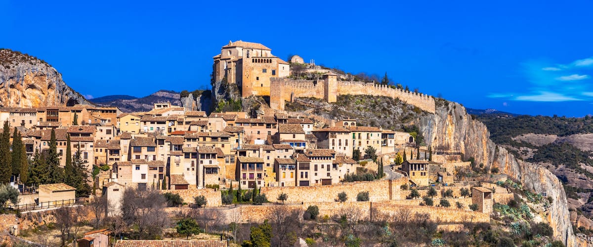 A historic town perched on a cliff with a prominent castle-like structure on top.