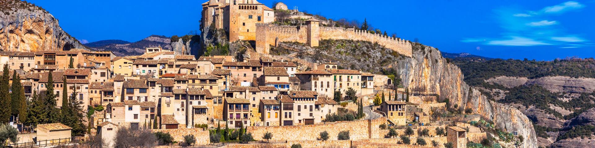 A historic town perched on a cliff with a prominent castle-like structure on top.