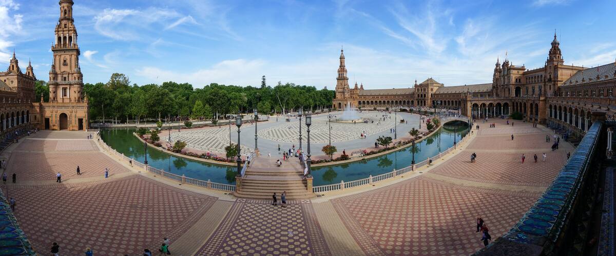 A large open plaza with a central fountain, surrounded by historic buildings with domes and towers.