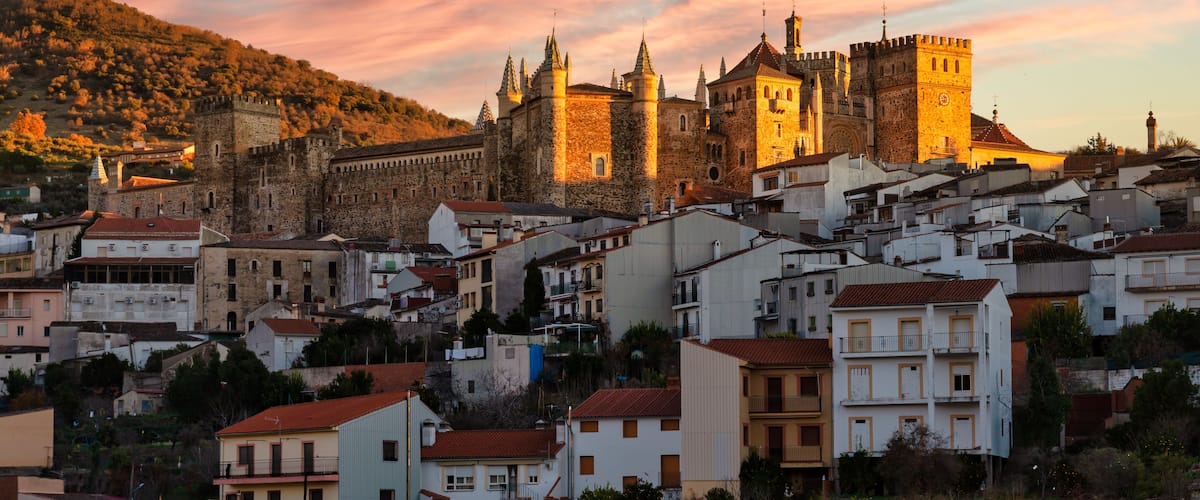 Un château historique doté de nombreuses tours, entouré d’une ville avec de beaux bâtiments.