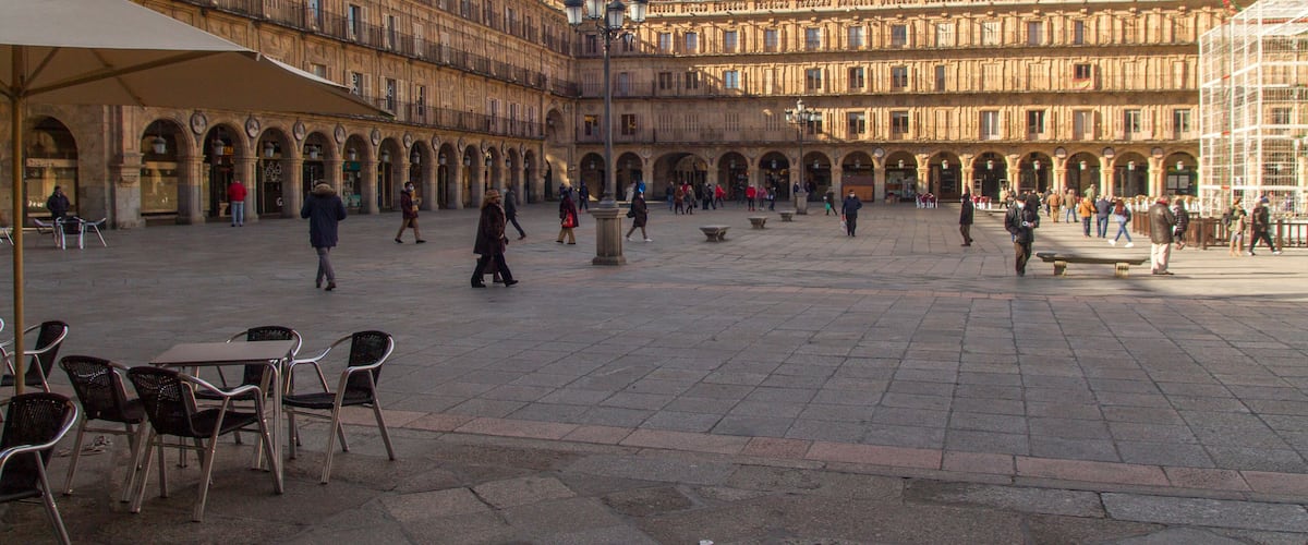 Un amplio patio con un edificio grande y ornamentado, que cuenta con múltiples arcos y columnas.