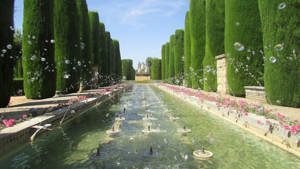 Pools and fountains in the Avenue of the Kings in the gardens of the Alcázar de los Reyes Cristianos, within the city of Córdoba, Andalusia, Spain. The gardens are laid out on what was once the vegetable gardens which supplied the Alcázar. The gardens are supplied with water from the Albolafia water mill and consist of terraced pools, fountains and landscaped avenues.