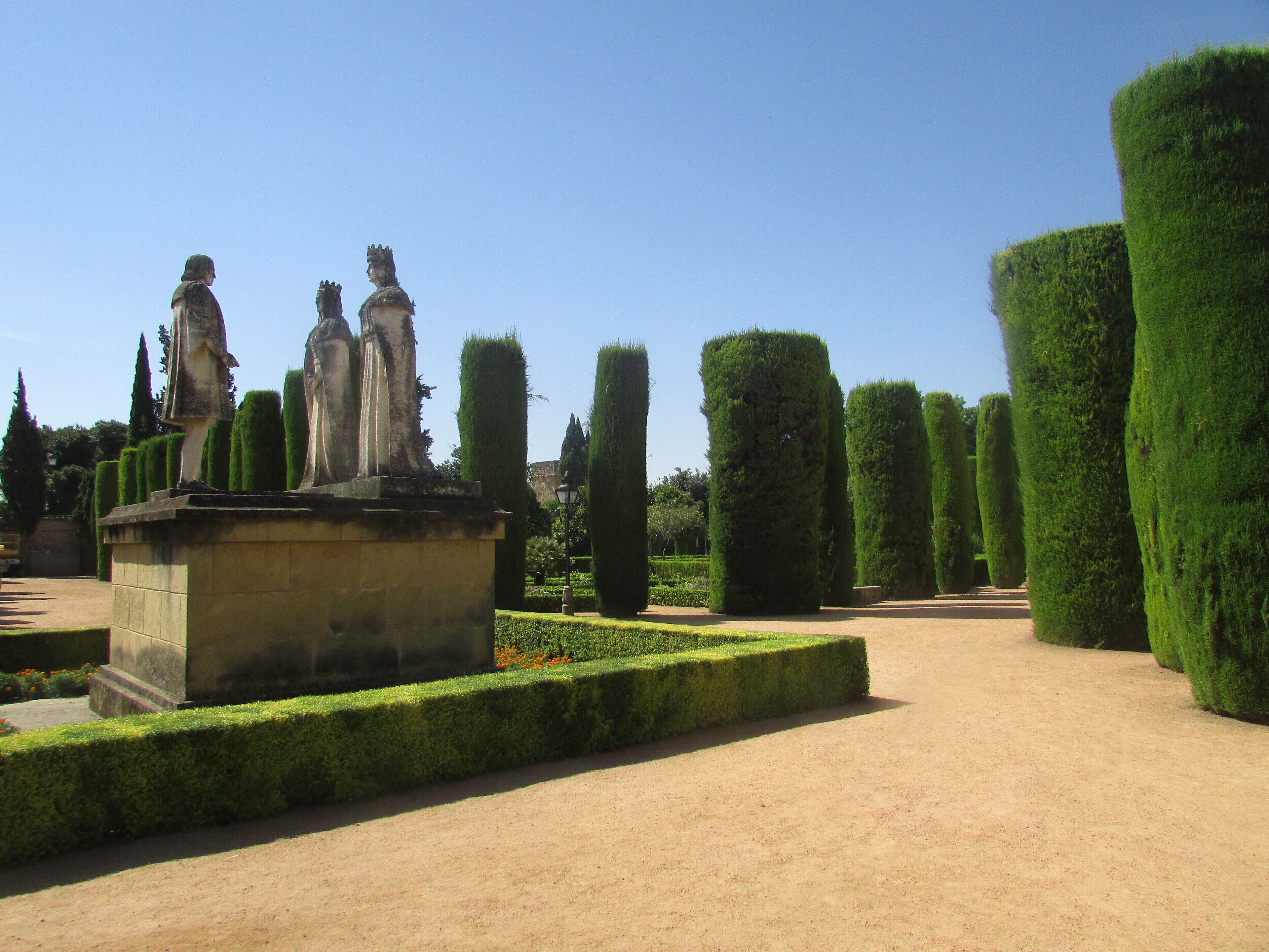 Un jardín con estatuas y setos perfectamente recortados.