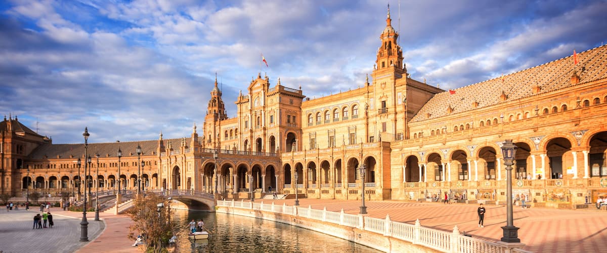Ein prächtiges, historisches Gebäude mit mehreren Bögen und einem Fluss im Vordergrund.