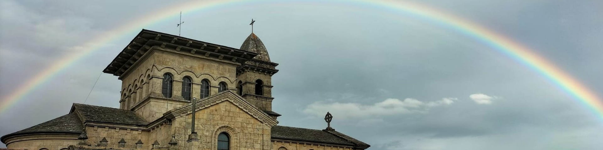 Uma igreja com um arco-íris sobre ela.