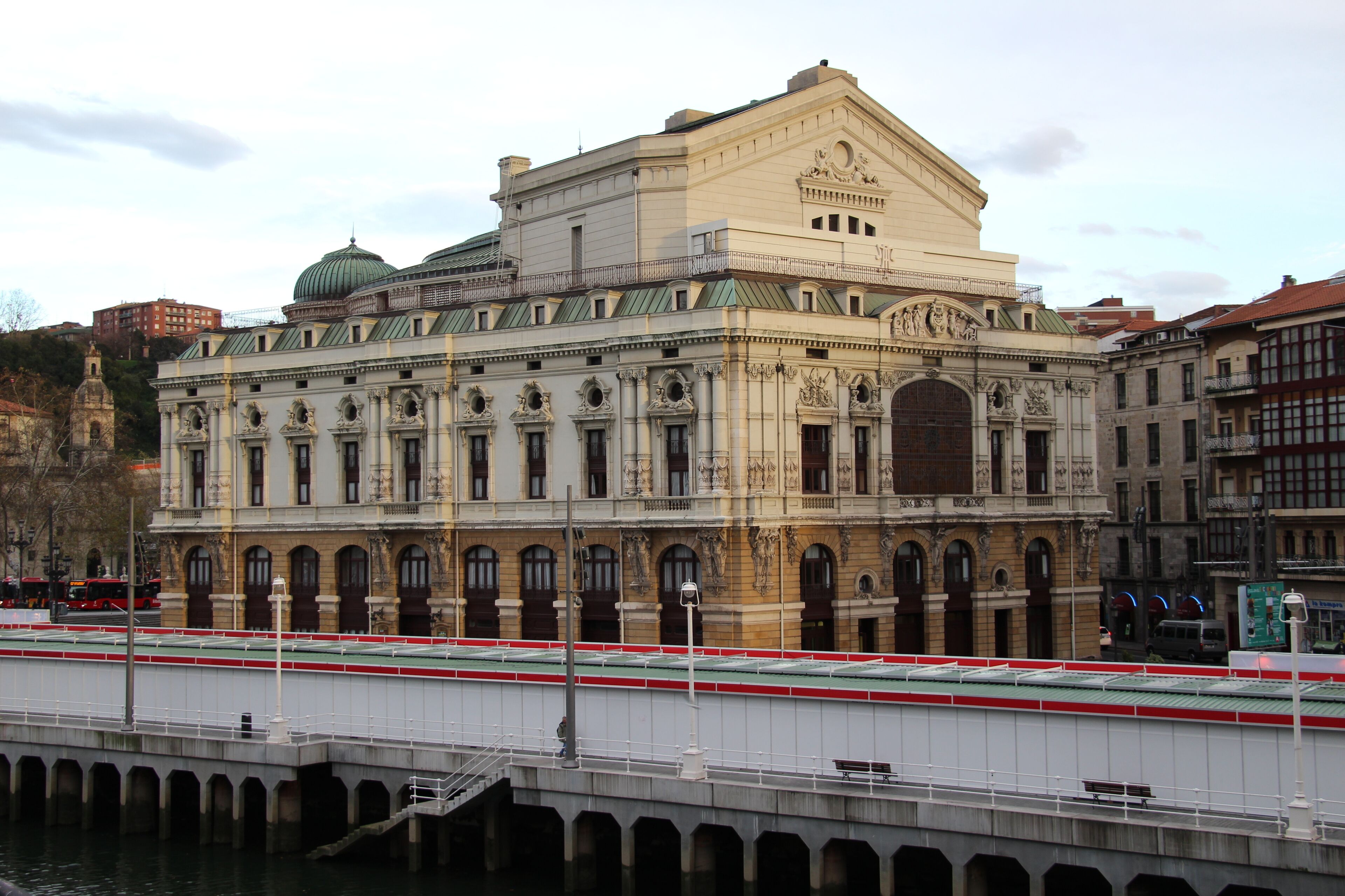 A historic building with ornate architecture, a bridge, and a river.