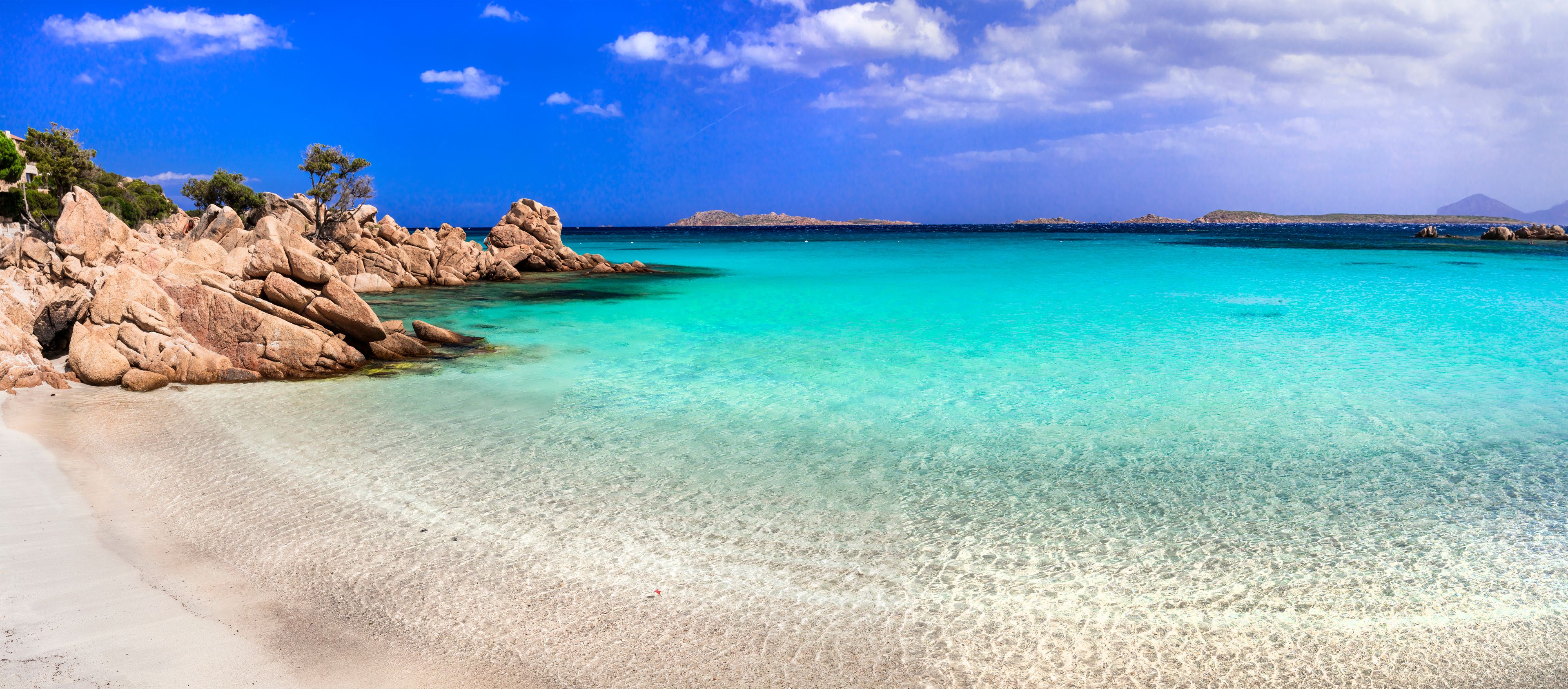 European Caribbean Sardinia Capriccioli beach ultra high resolution panorama with pink sand and turquoise emerald sea Costa Smeralda Italy drone travel destination wide angle landscape