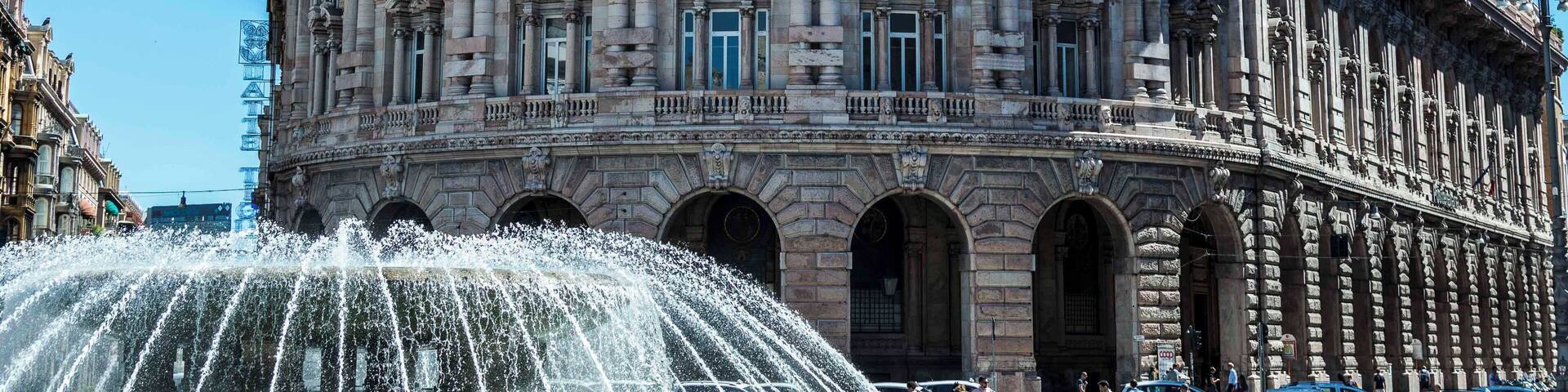 A historic building with ornate architecture and a fountain in front.