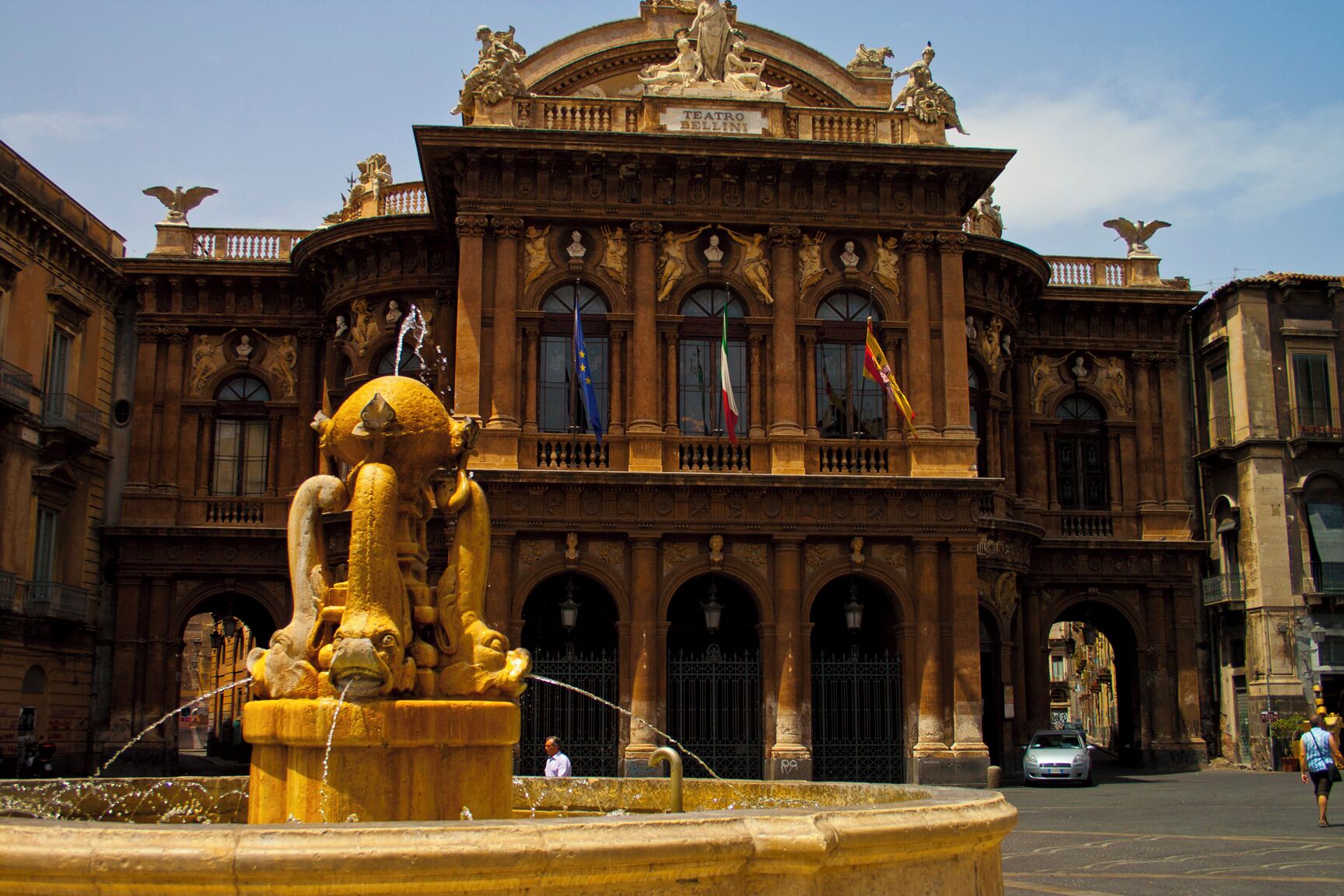 Un edificio imponente con esculturas ornamentales y banderas.