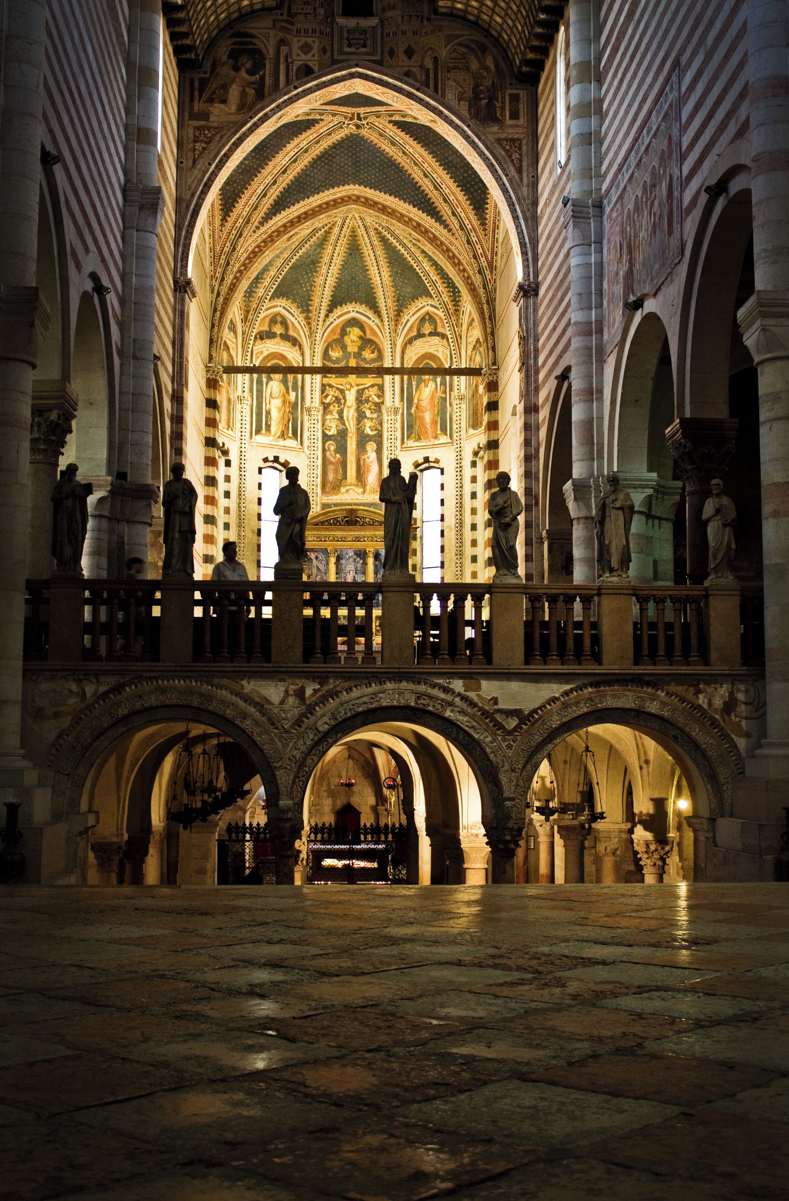 A cathedral interior with a large arched ceiling, statues, and a balcony.