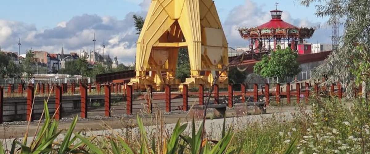 Cette grue Titan, de 43 m de hauteur, a été installée sur le site des chantiers Dubigeon en 1955 pour lever des éléments préfabriqués de bateaux pour le montage sur cale. Au fond, le carrousel des mondes marins. Article de Wikipedia sur les grues Titan fr.wikipedia.org/wiki/Grue_Titan