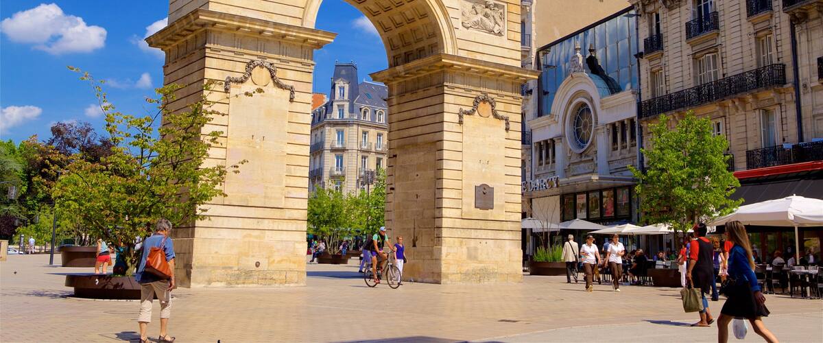 The Arc de Triomphe in Paris, surrounded by historic buildings and people walking around.