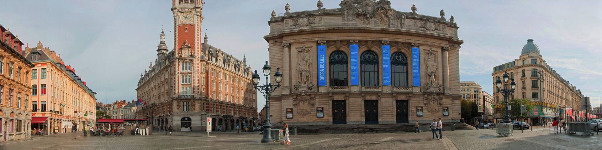A historic opera house with a prominent clock tower and ornate architecture.