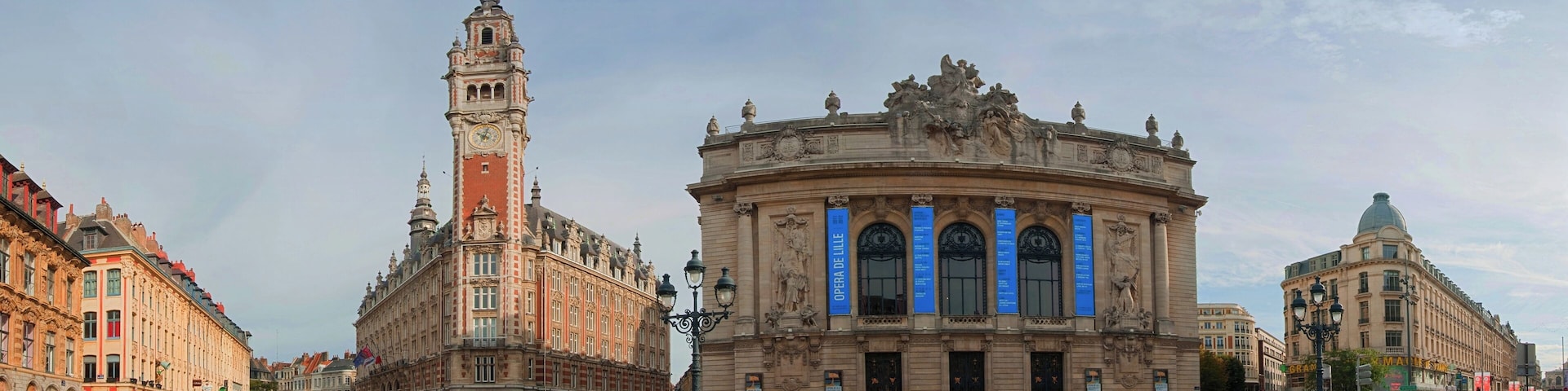 Un teatro de ópera histórico con una imponente torre de reloj y arquitectura ornamentada.