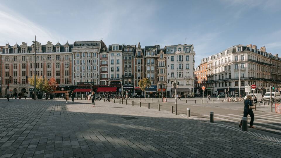 Ein historischer europäischer Stadtplatz mit Kopfsteinpflaster, klassischer Architektur und verschiedenen Geschäften sowie Cafés.