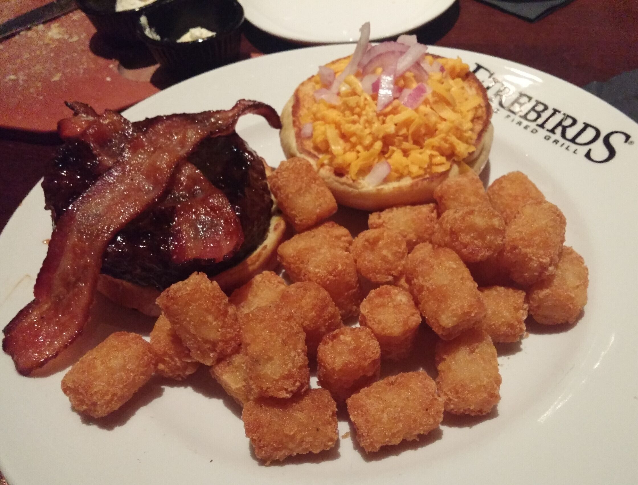 The Smokehouse Burger from Firebirds Wood Fired Grill in the Polaris area topped with java BBQ sauce, apple-wood smoked bacon, cheddar and red onion with a side of tots.

#delicious 