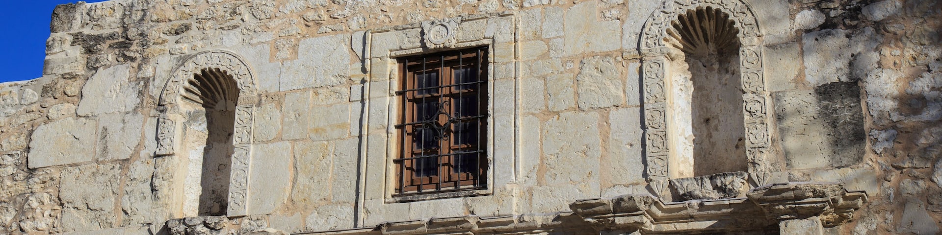 A historic stone building with arched windows and intricate carvings.
