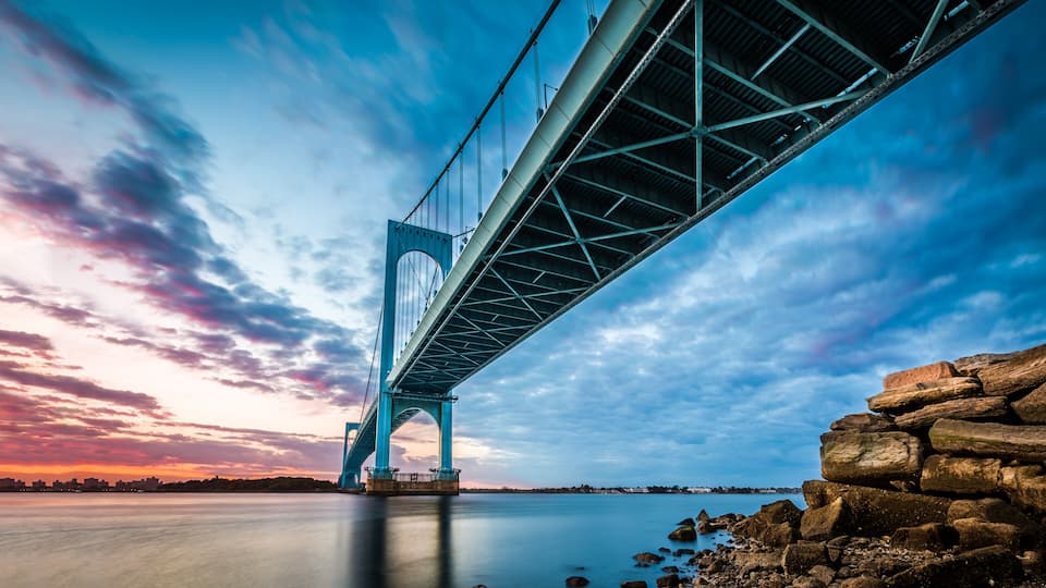 Uma grande ponte suspensa sob um céu claro e um pôr do sol.