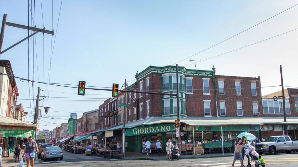 A street corner with a green awning storefront named "GIORDANO" and a "No Parking" sign.