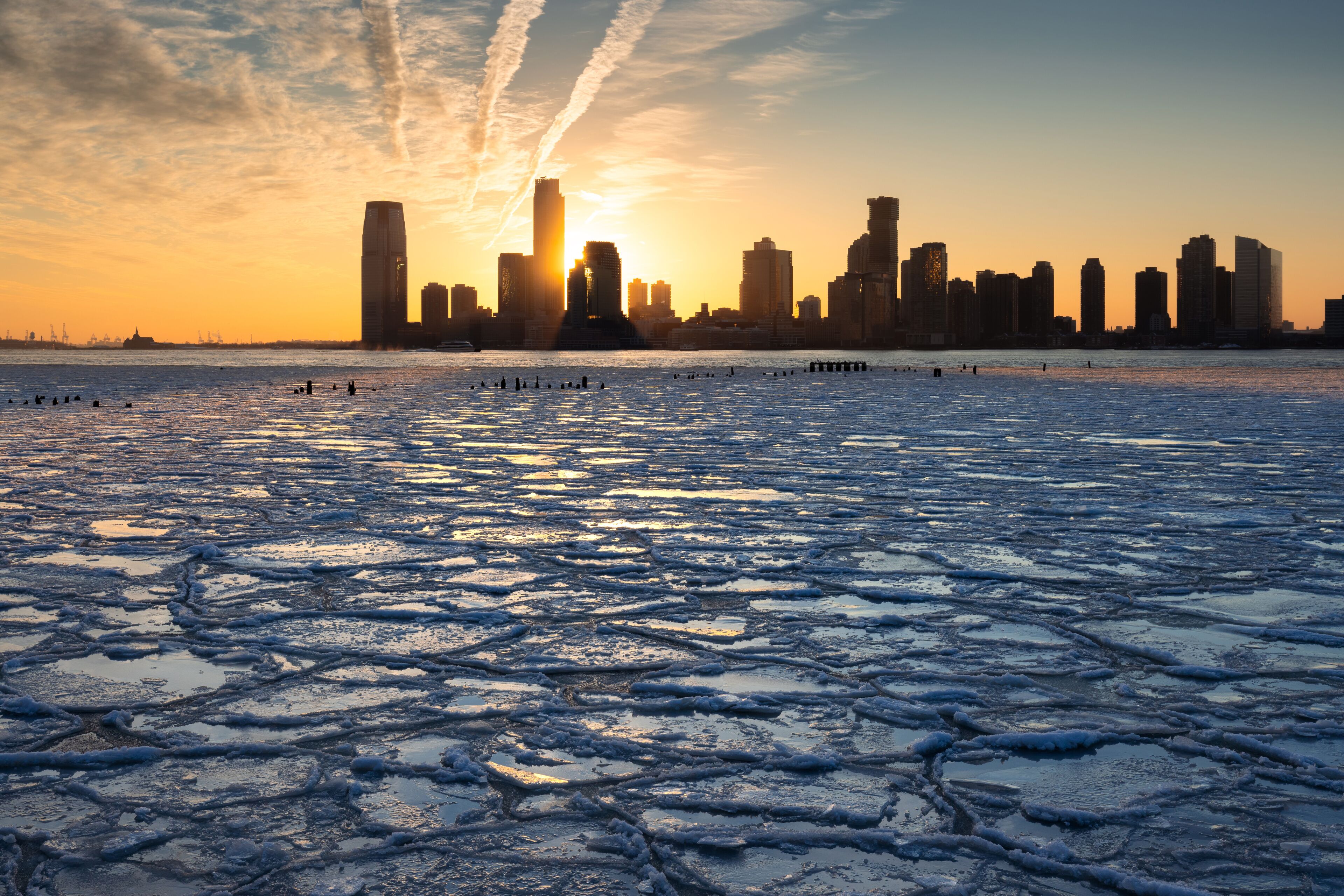 Sunset on the frozen Hudson River with skyline view of Downtown Jersey City skyscrapers (Exchange Place and Newport). New Jersey 
