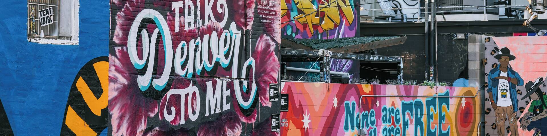 A colorful mural on a building with graffiti and text.