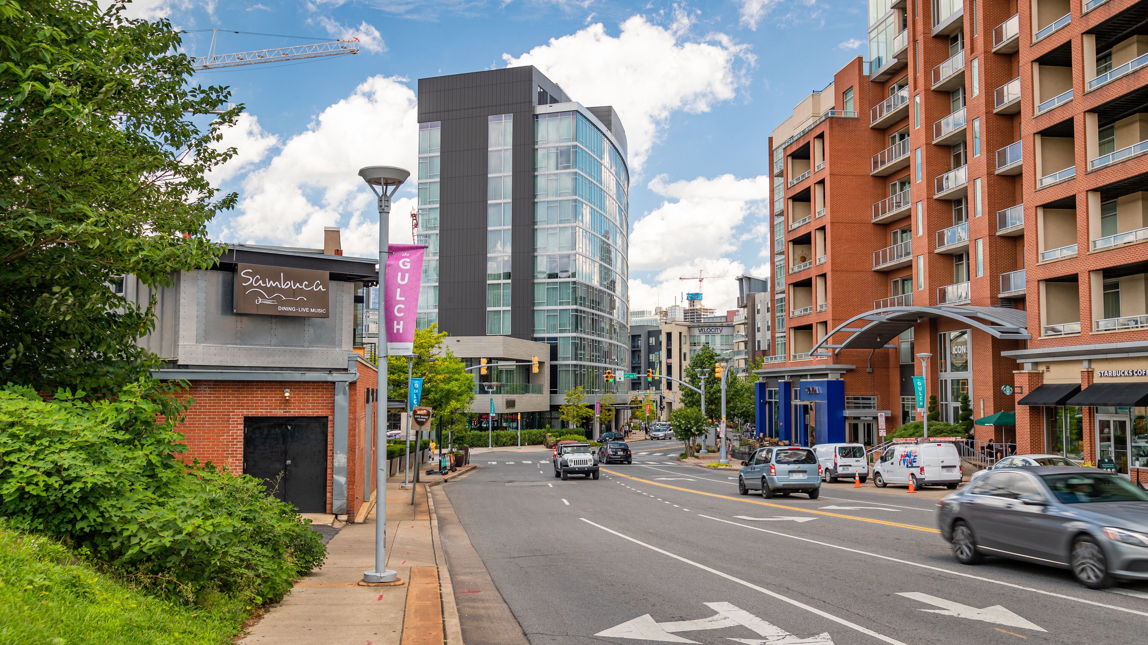 A city street with buildings, cars, and a traffic light.