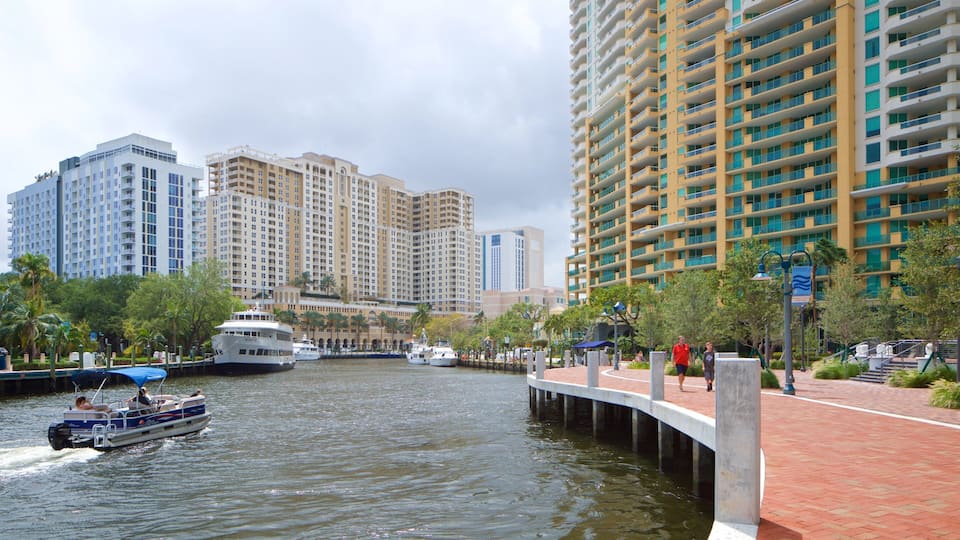 A river with boats, a bridge, and high-rise buildings in the background.