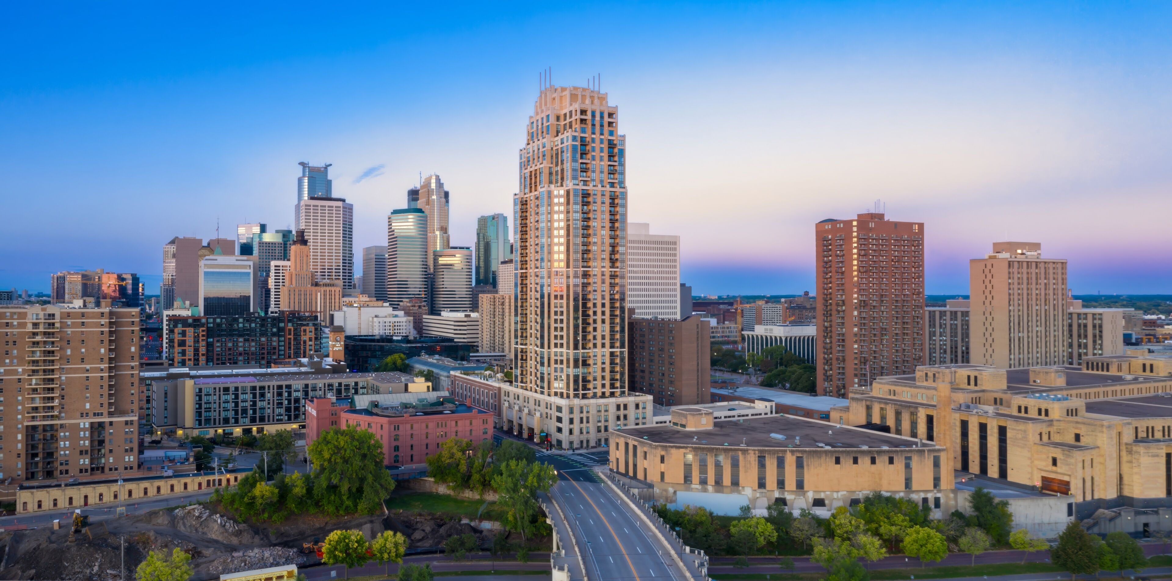 Minneapolis skyline at dawn, showcasing modern and historic architecture. Urban development and revitalization. Downtown West, Minneapolis, Minnesota, United States