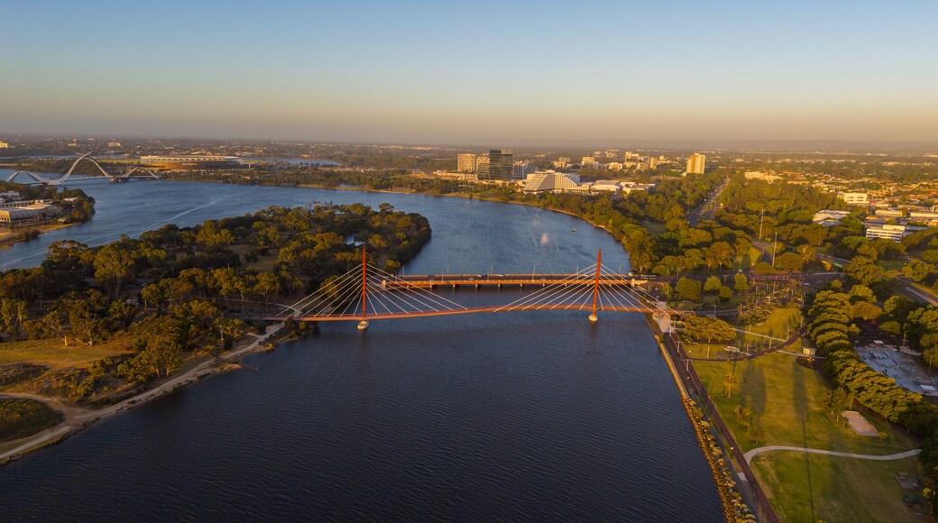 Aerial view of Perth city skyline with Boorloo bridge lit up connecting Heirisson island with walking and cycling path along the Swan river