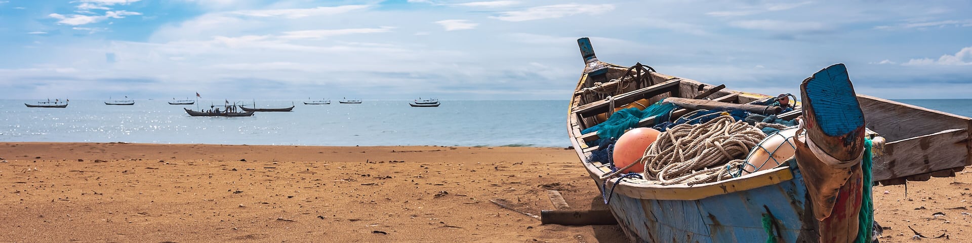 Fishing boat missions on the beach waiting for the next fishing trip. This boat is located on the tropical shore of Keta Ghana West Africa 2021