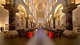 A grand cathedral interior with high arched ceilings, marble columns, and rows of pews.