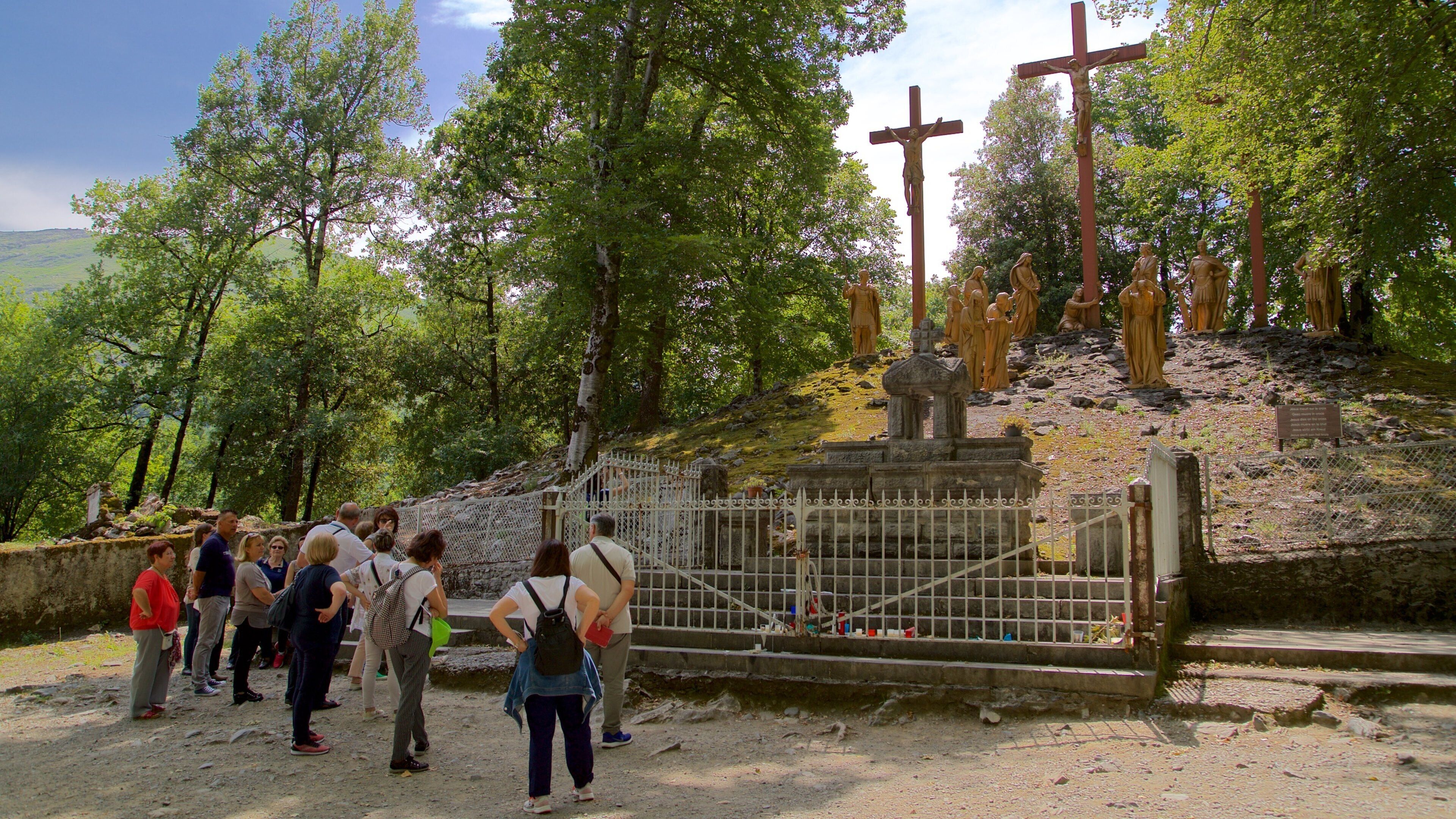 Le Chemin de Croix qui includes statue ou sculpture et éléments religieux aussi bien que petit groupe de personnes