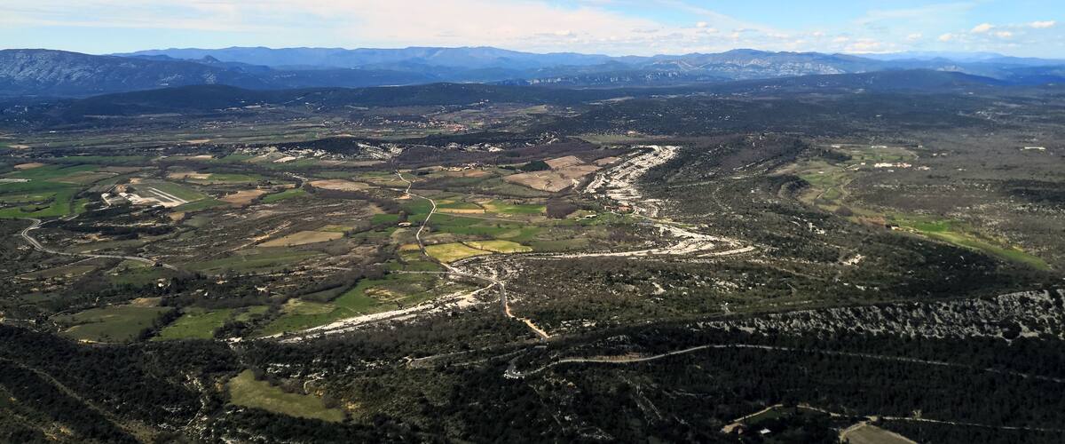 A mountainous landscape with winding roads and patches of greenery.