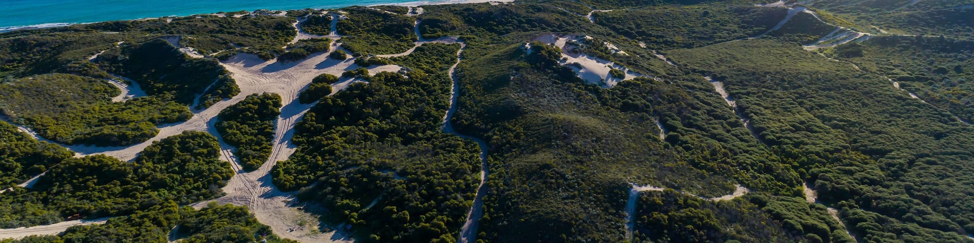 Aerial view of sandy beach with waves and trees. Sunny day in summer with transparent tropical blue water. Travel to Shorehaven Beach, Western Australia. Top view. Coastal, Seascape