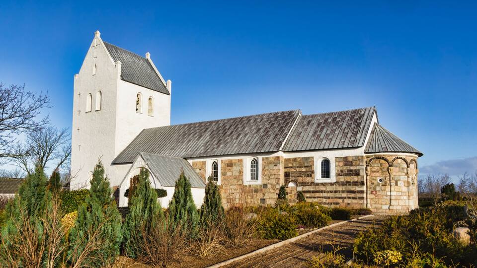 A church with a tall tower and stone walls.