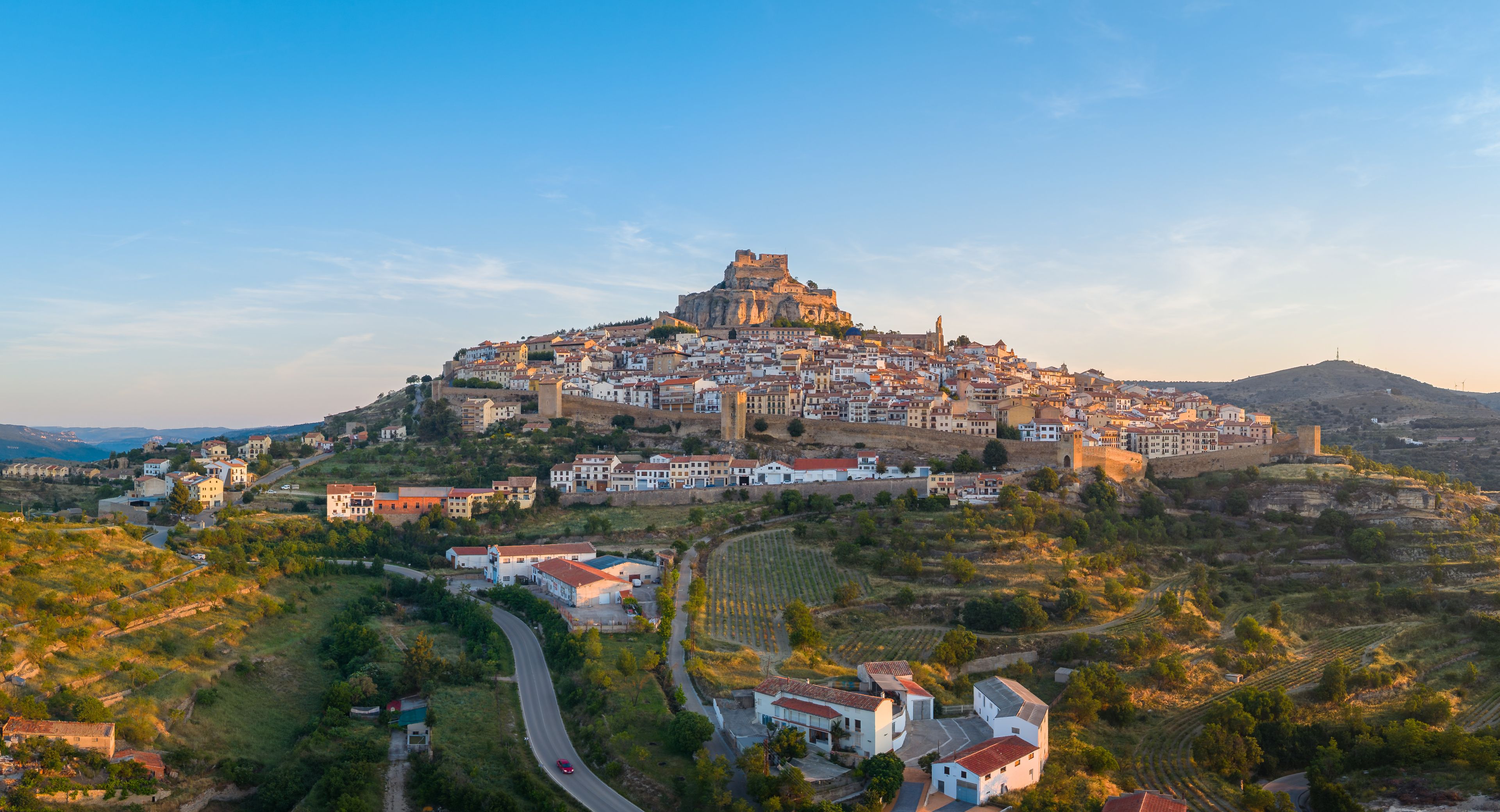 Panoramic view of Morella, medieval walled town with hilltop castle at sunrise, vineyard terraces and valley landscape, Els Ports, Castellon, Valencian Community, Spain