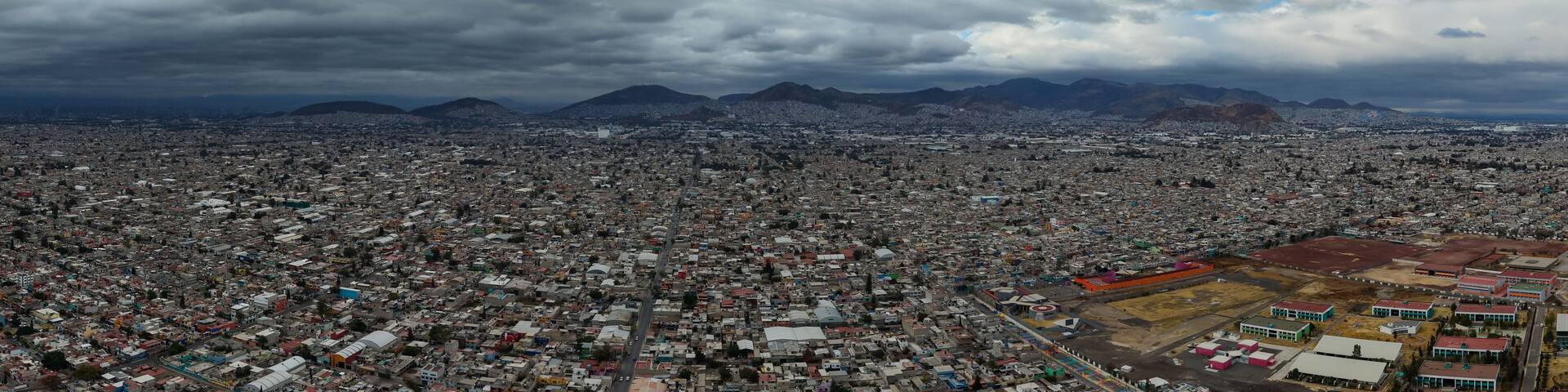 A densely populated cityscape with a mountain range in the background.