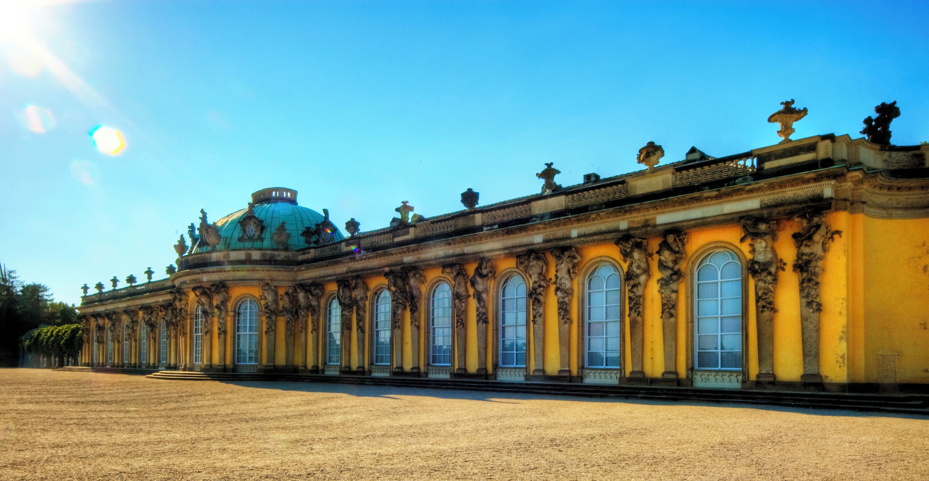 Get the large view! Sanssouci(French "carefree") is the former summer palace of Frederick the Great, King of Prussia at Potsdam, just outside Berlin. It is often counted among the German rivals of Versailles. While Sanssouci is in the more intimate Rococo style and is far smaller than its French Baroque counterpart, it is notable for the numerous temples and follies in Sanssouci Park. Designed by Georg Wenzeslaus von Knobelsdorff between 1745 and 1747 to fulfil Frederick's need for a private residence where he could relax away from the pomp and ceremony of the Berlin court, the palace is little more than a large single-storey villa—more like the Château de Marly than Versailles. Containing just ten principal rooms, it was built on the brow of a terraced hill at the centre of the park. So great was the influence of Frederick's personal taste in the design and decoration of the palace that its style is characterised as "Frederician Rococo", and so personally did he regard the palace that he conceived it as "a place that would die with him". Because of a disagreement about the sight of the palace from the park Knobelsdorff was fired in 1746. Jan Bouman, a Dutch architect finished the project. During the 19th century, the palace became a residence of Frederick William IV. He employed the architect Ludwig Persius to restore and enlarge the palace, while Ferdinand von Arnim was charged with improving the locality and thus the view from the palace. The town of Potsdam, with its palaces, was a favourite place of residence for the German imperial family until the fall of the Hohenzollern dynasty in 1918. After World War II, the palace became a tourist attraction in East Germany. It was fully maintained with due respect to its historical importance, and was open to the public. Following German reunification in 1990, the final wish of Frederick came to pass: his body was finally returned to his beloved palace and buried in a new tomb overlooking the gardens he had created. Sanssouci and its extensive gardens became a World Heritage Site in 1990 under the protection of UNESCO; in 1995, the Foundation for Prussian Palaces and Gardens in Berlin-Brandenburg was established to care for Sanssouci and the other former imperial palaces in and around of Berlin. These palaces are now visited by more than two million people a year from all over the world. From Wikipedia, the free encyclopedia
