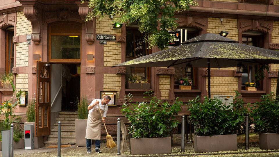 A man sweeping the entrance of a building with a broom.