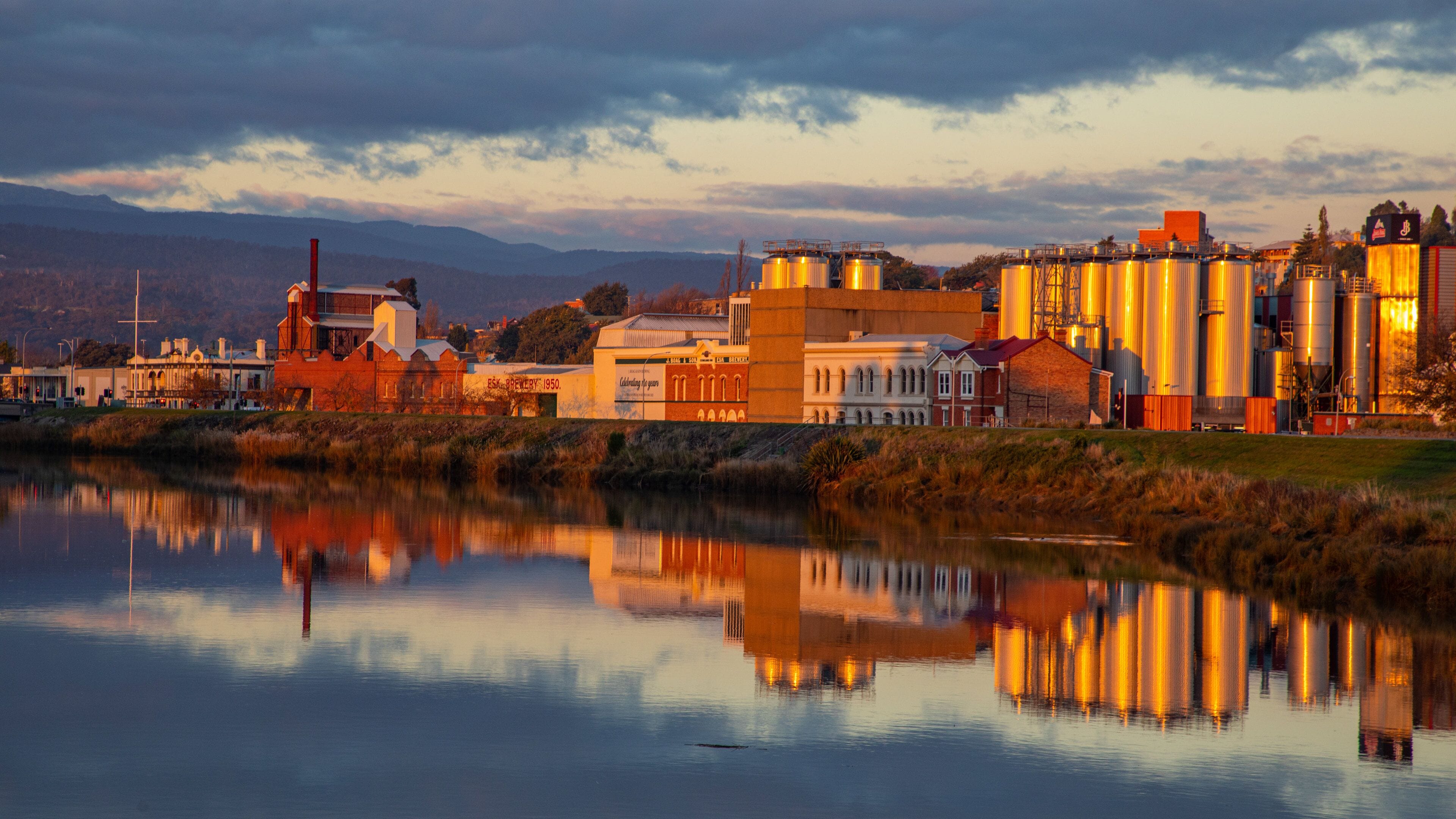 Launceston CBD which includes a sunset, a small town or village and a river or creek