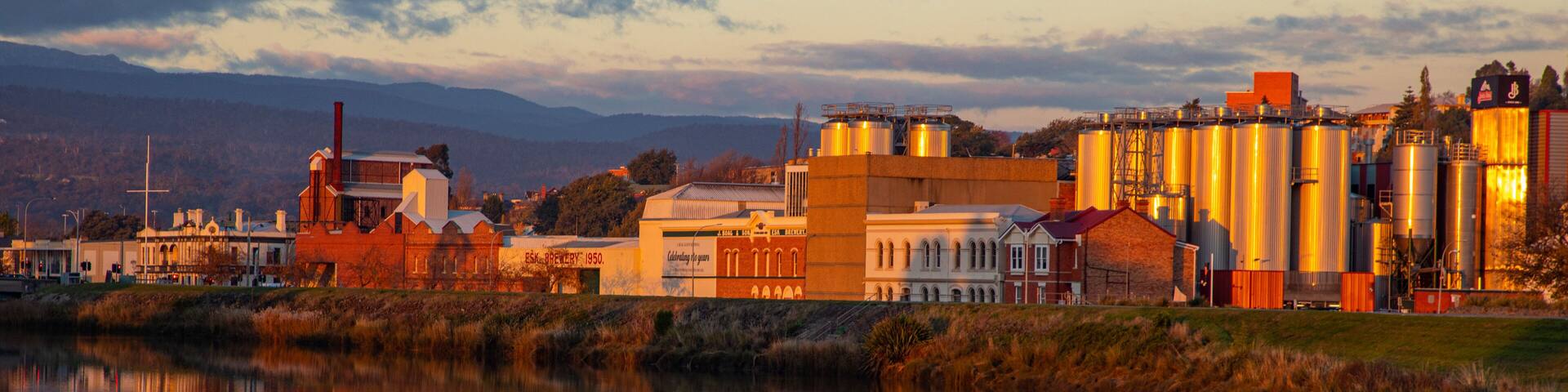 Launceston CBD which includes a sunset, a small town or village and a river or creek