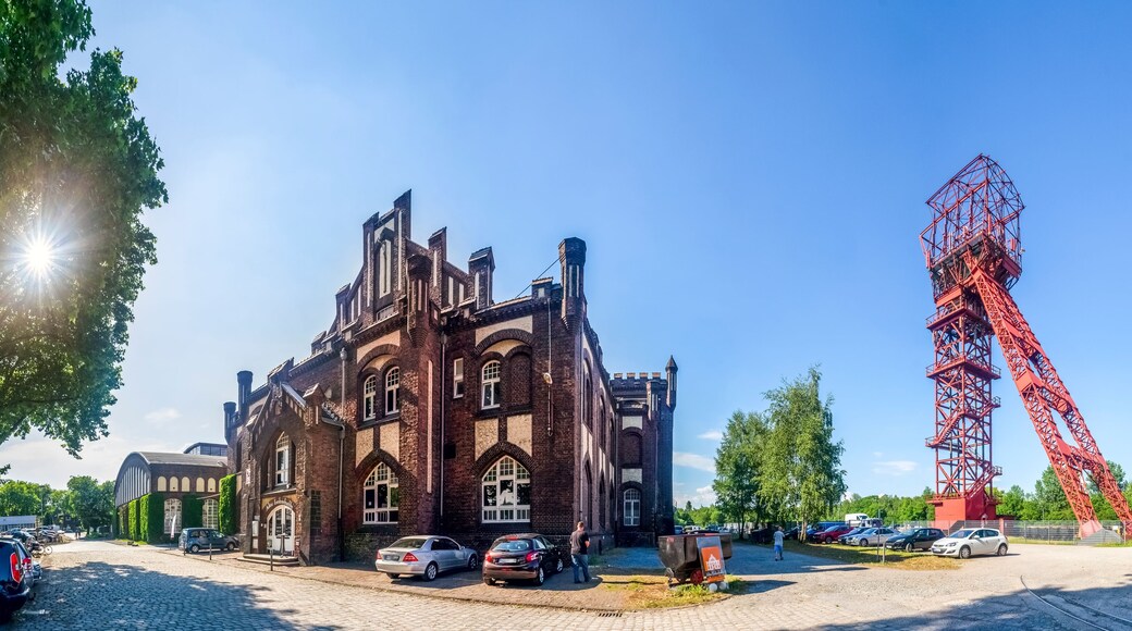 Ein historisches Gebäude mit rundbogigen Fenstern und einer roten Kränlkonstruktion.