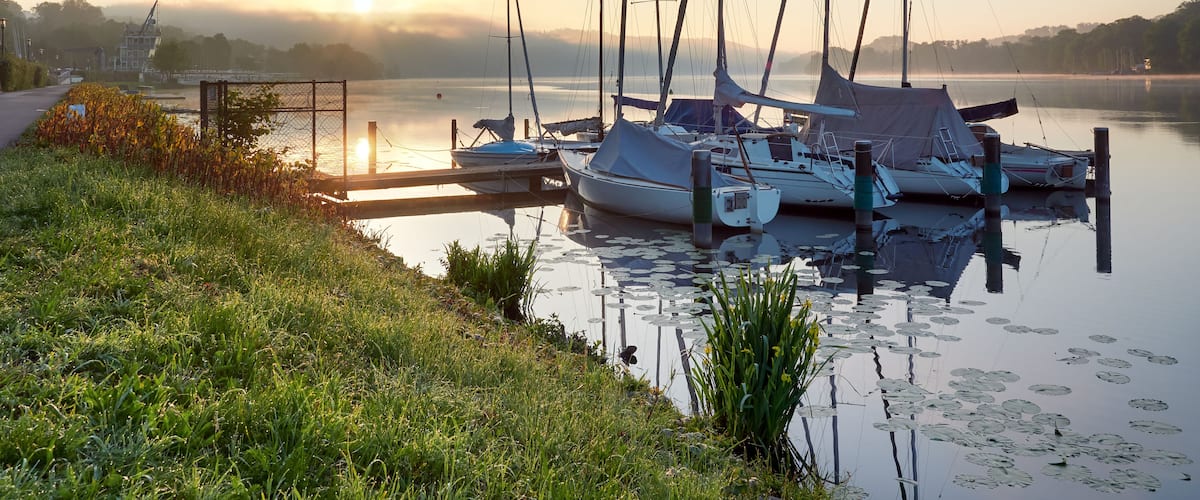 A wonderful sunrise over Lake Baldeneysee in the city of Essen. Moored sailboats in the foreground. Landscape photography