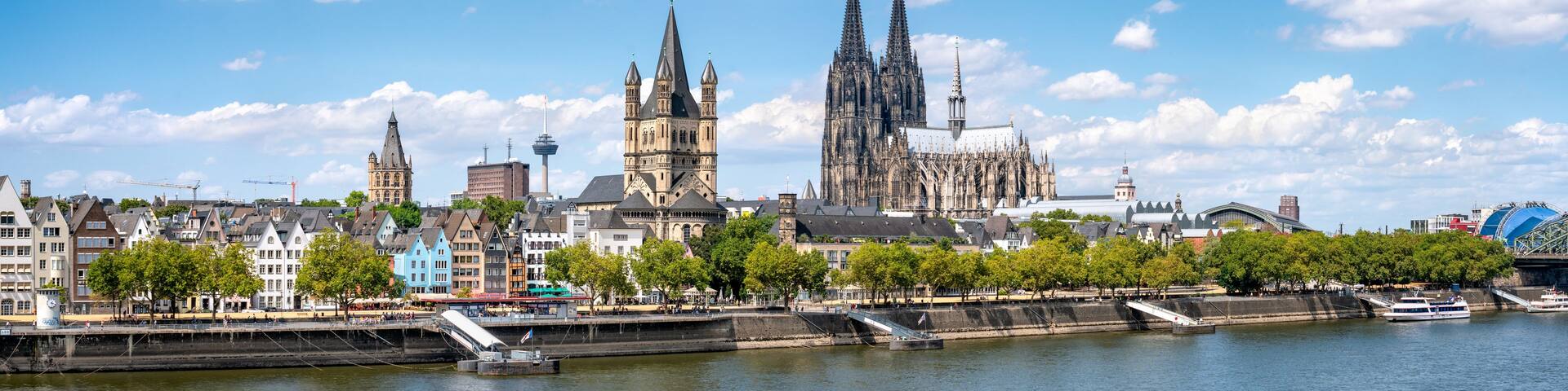 A river with boats, a bridge, and a city skyline with historic buildings.
