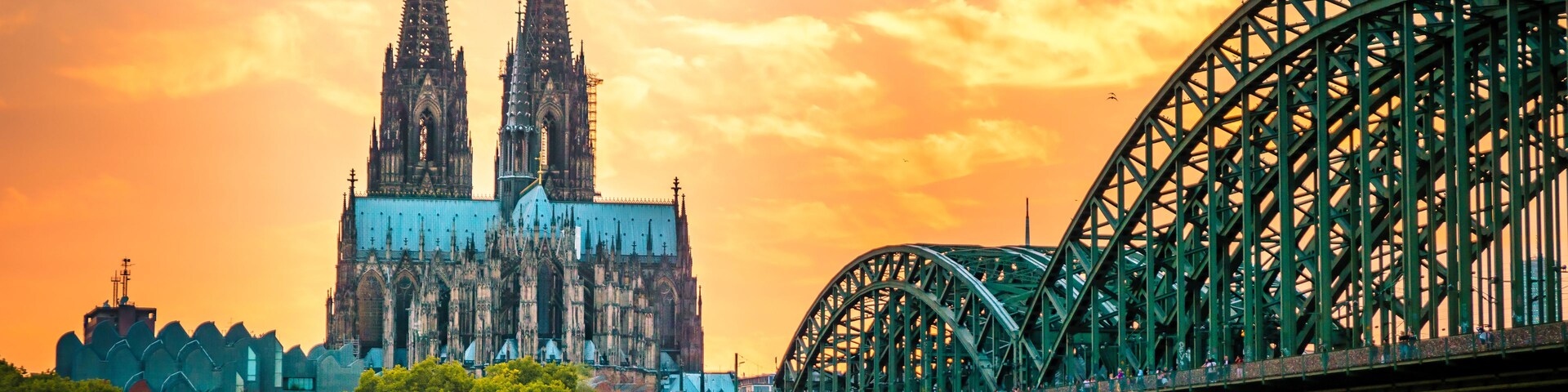 Uma ponte, um rio e uma catedral com duas torres.
