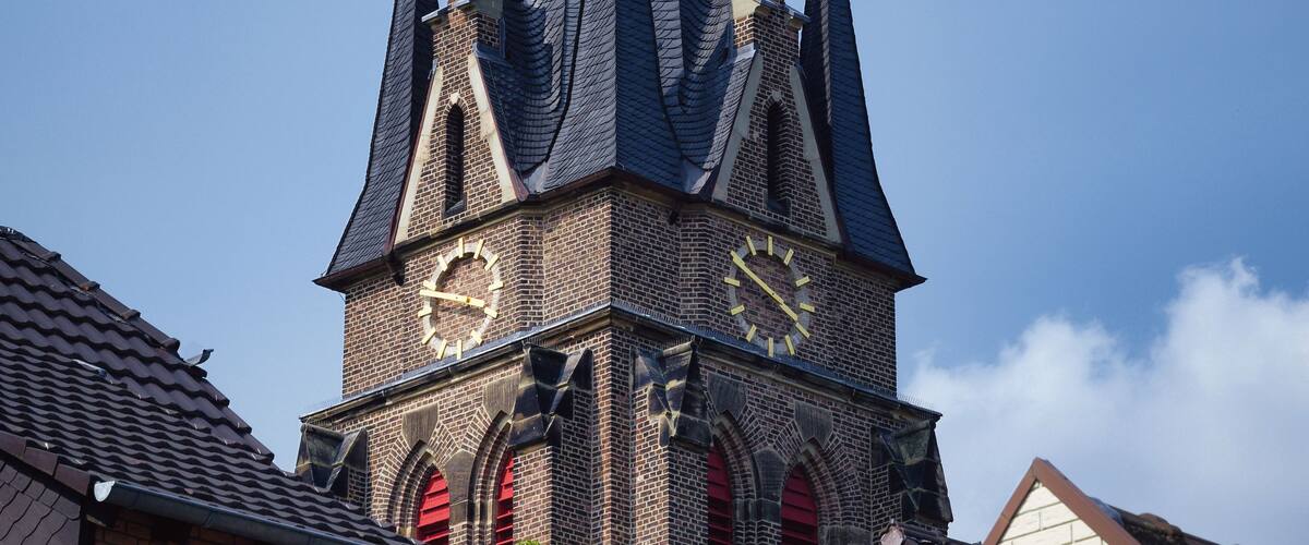 A church with a tall spire and a weather vane.