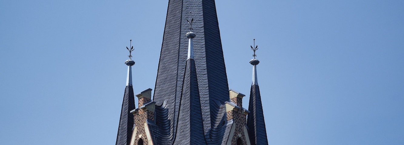 Uma igreja com uma torre alta e um indicador de vento.