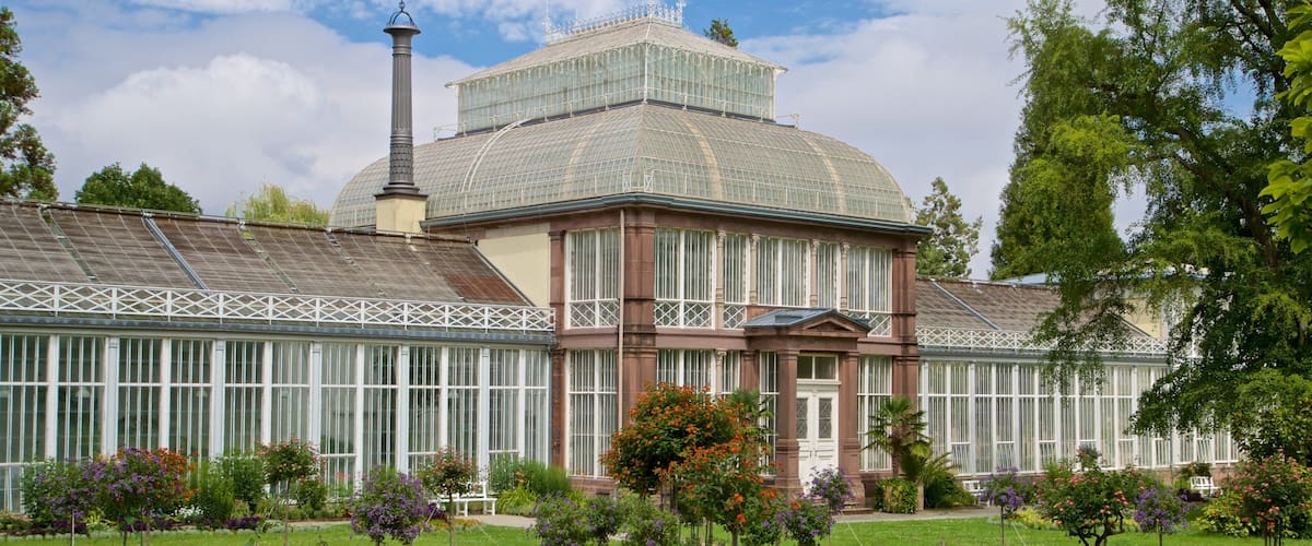 A large glass conservatory with a central dome and a bell tower.